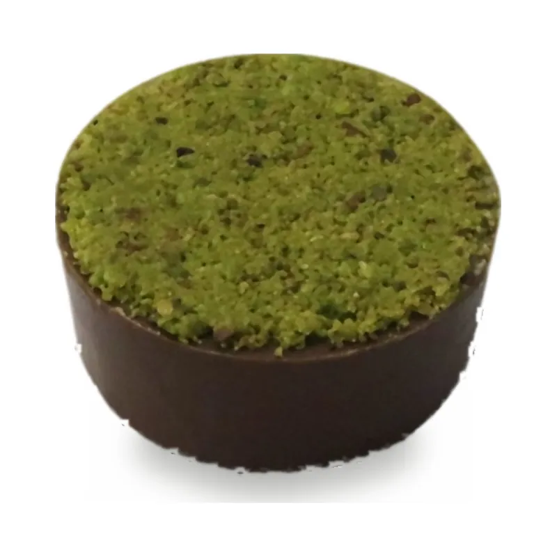 A dark chocolate cup topped with green pistachio crumb