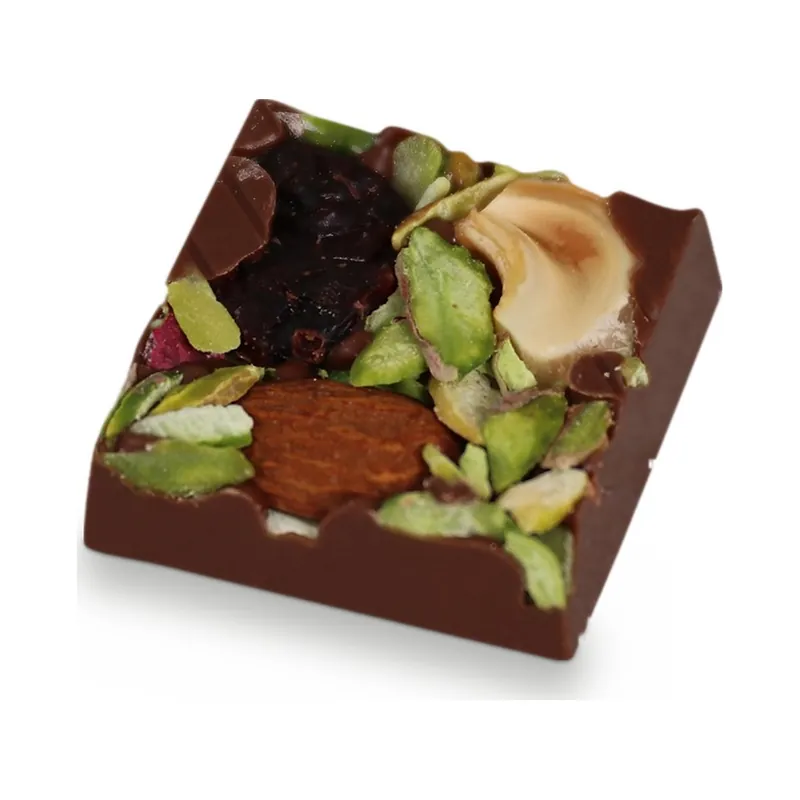 A dark chocolate square topped with pistachios and dried fruit